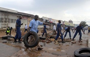 Burundi policemen clear a barricade set up by protestors opposing President Pierre Nkurunziza from running for a third term, in Bujumbura