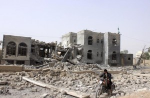 A man rides a motorcycle past a headquarters of the Houthi group, which was destroyed after an air strike by a Saudi-led coalition, in Yemen's northwestern city of Saada April 26, 2015. REUTERS/Stringer