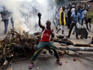 A protester sits in front of a burned barricade during a protest against Burundi President Pierre Nkurunziza and his bid for a third term in Bujumbura, Burundi, May 21, 2015. REUTERS/Goran Tomasevic