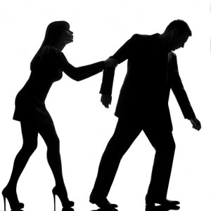 one caucasian couple dispute separation man leaving and woman holding back in studio silhouette isolated on white background