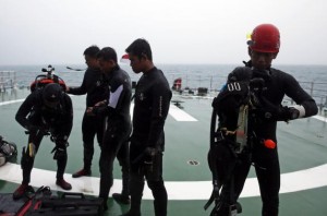 Group of divers prepares their gear on the deck of the SAR ship KN Purworejo during a search operation for passengers onboard AirAsia Flight QZ8501 in the Java Sea