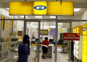 Man speaks on a mobile phone as he walks past a MTN shop at a shopping mall south of Johannesburg