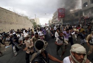Anti-Houthi protesters run as pro-Houthi police troopers open fire in the air to disperse them in Yemen's southwestern city of Taiz