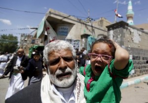 An injured girl reacts as she is carried by a man out of a mosque which was attacked by a suicide bomber in Sanaa