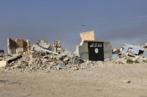 A destroyed building with a wall painted with the black flag commonly used by Islamic State militants, is seen in the town of al-Alam