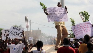 A protester carries a placard as they chant anti-government slogans during demonstrations against the ruling CNDD-FDD party's decision to allow Burundi President Pierre Nkurunziza to run for a third five-year term in office, in Bujumbura, May 4, 2015. REUTERS/Jean Pierre Aime Harerimana