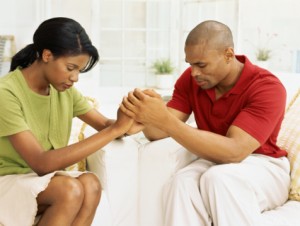 mid adult couple holding hands and praying