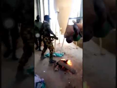 Nigerian soldiers roasting a man