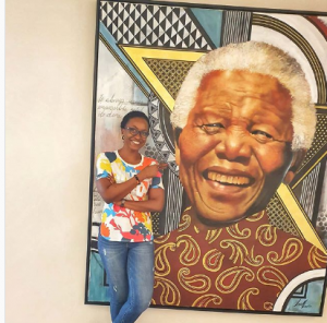 Kate Henshaw while standing close to late Nelson Mandele's portrait