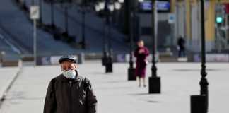 A man wearing a protective face mask walks along the street in Moscow, Russia [Shamil Zhumatov/Reuters]