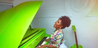 omawumi pressing a green piano