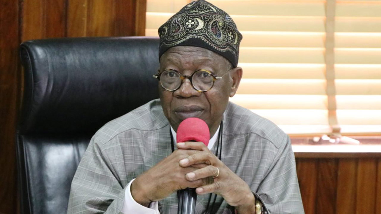Lai Mohammed with a red head microphone